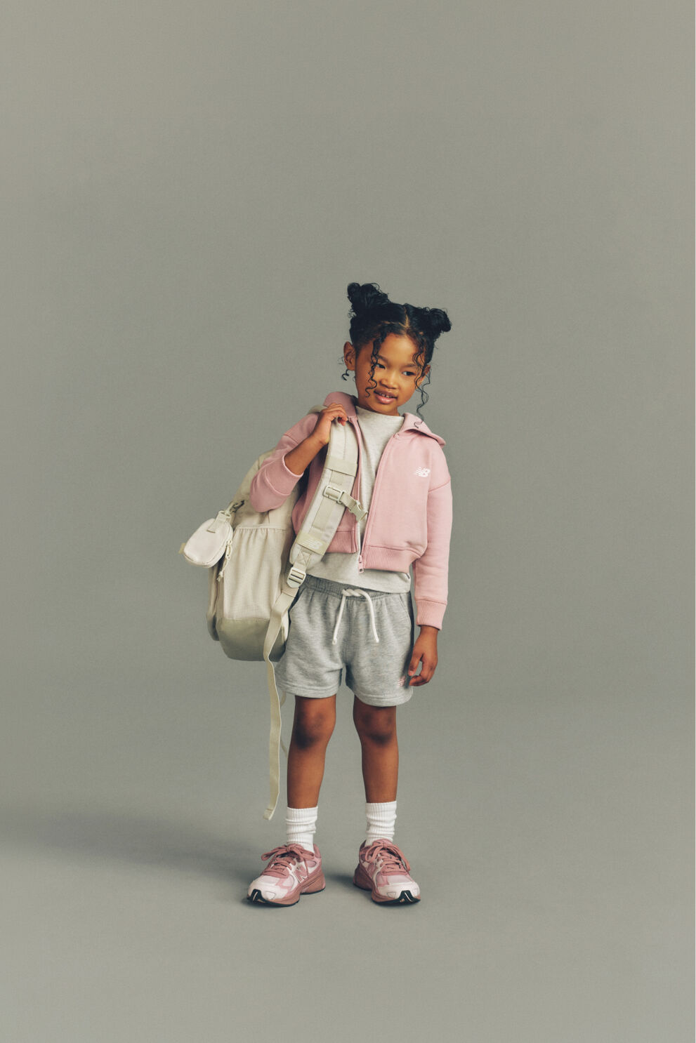 Child standing on a pile of books.